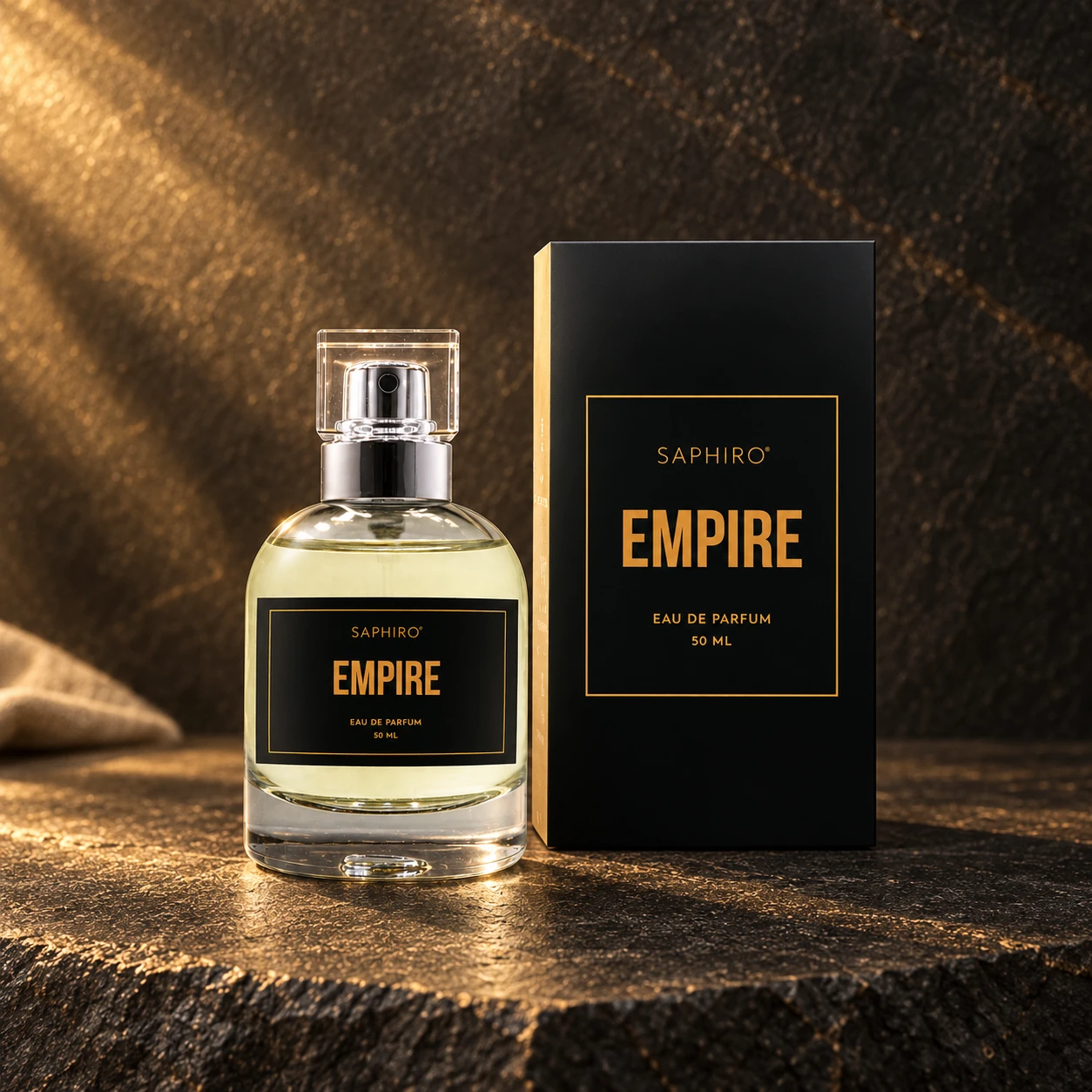 Flakon parfému Saphiro Empire s původním obalem na tmavém kameni ve zlatém světle
