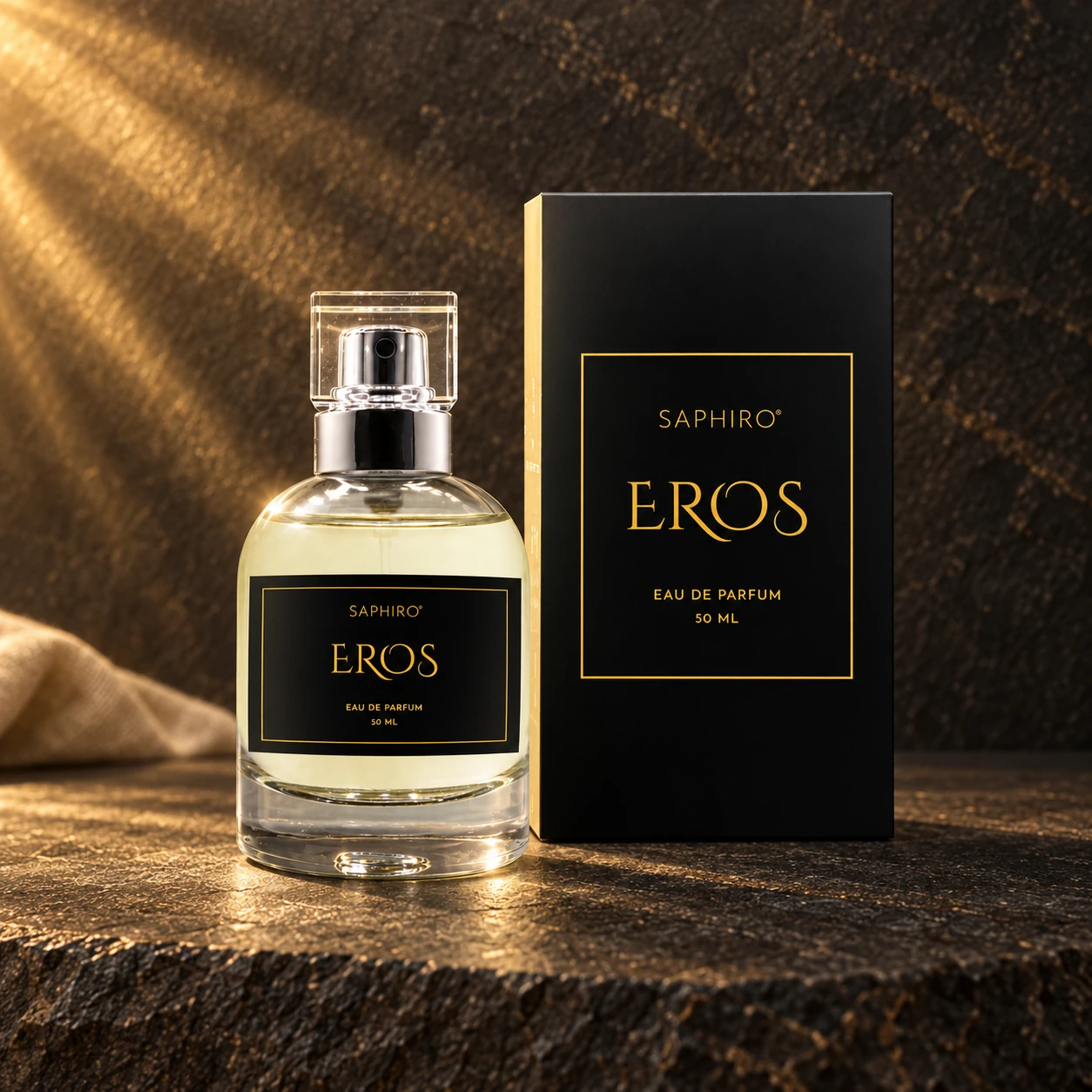 Flakon parfému Saphiro Eros s původním obalem na tmavém kameni ve zlatém světle