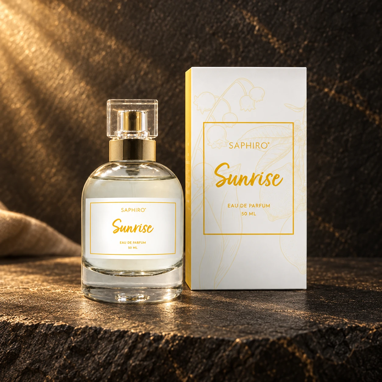 Flakon parfému Saphiro Sunrise s původním obalem na tmavém kameni ve zlatém světle